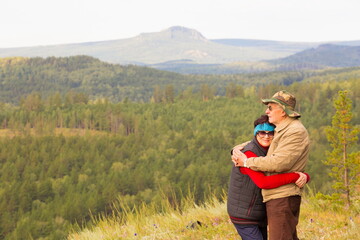 beautiful mature couple on the slope of the mountain of the southern Urals on a summer day