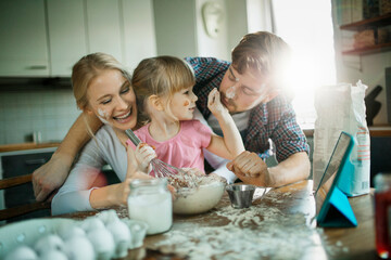 Young family baking and being messy in the kitchen at home