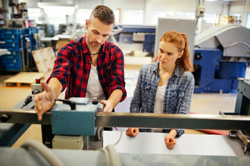 Young man and woman working in a printing press office