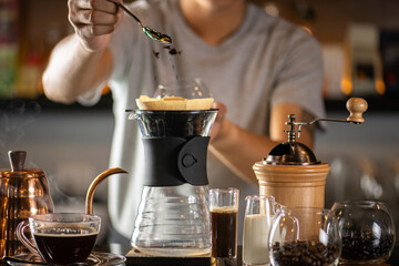 drip coffee, Barista making drip coffee by pouring spills hot water on coffee ground with prepare...