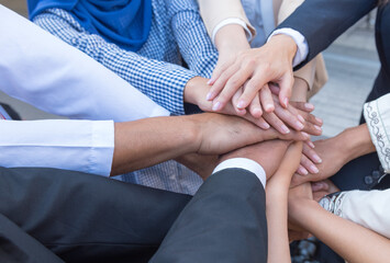 Persian and Arab business people join hands oneness. Unity and teamwork show by Stack mix of hands...