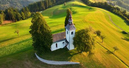 Aerial view of St. Thomas church on top of a hill, sunrise, Skofja Loka, Slovenia