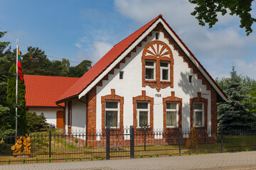 Fototapeta na wymiar Brick rural house with red roof in Lithuanian countryside