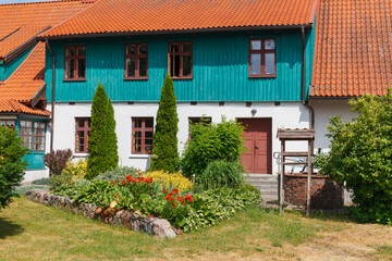 Colorful rural house with red roof in Lithianian countryside - obrazy, fototapety, plakaty