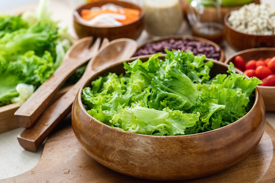 Hand chef mix fresh baby cos salad millet Crab Stick and pour salad dressing in wood blow. Organic Vegetables mix lunch with green salad In bowl. Breakfast fresh salad and clean vegetable