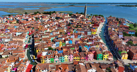 Aerial view of the Church of Saint Martin Bishop and Campanile Pendente on Burano Island near Venice, with colorful houses, Veneto Region, Italy