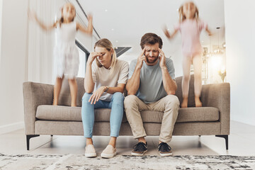 Frustrated parents, sofa and headache with children jumping in living room chaos, ADHD or crazy...