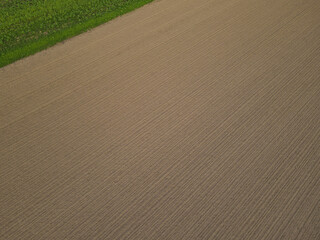 View from above of a brown plowed agriculture field with soil 