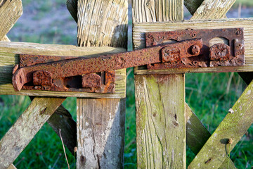 Rustic charm, a weathered metal latch on an aged wooden garden gate. A unique vintage photography.