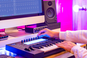 male musician, producer, compoer, arranger, songwriter recording music by midi keyboard, computer, speaker monitor, audio interface in home studio. music production concept  - obrazy, fototapety, plakaty