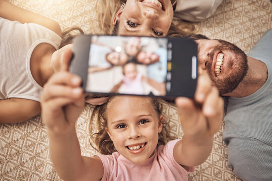 Selfie, phone and top view of family on a floor with love, fun and smile for social media post at home. Smartphone, profile picture and girl children with parents in a living room for weekend memory