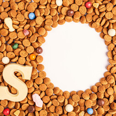 Dutch holiday Sinterklaas background with copy space fot text. Kruidnoten cookies and traditional hollands sweets. Concept for children party Saint Nicolas day. Top view.