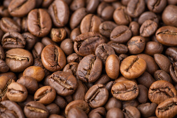 Close up of dark roasted coffee beans. Fresh aromatic coffee grain background