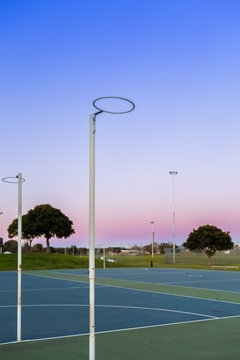 Netball hoop at empty community sports ground in dusk light
