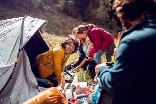 Young family setting up a tent while out camping in nature together