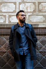 Portrait of young hipster in front of a wall