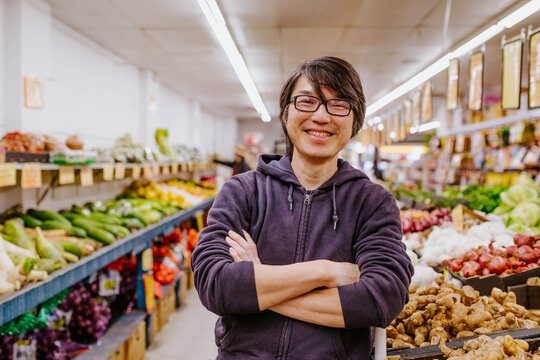 Chinese man with crossed arms working in fresh food store
