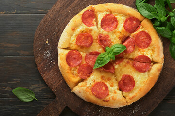 Pepperoni pizza. Traditional pepperoni pizza and cooking ingredients tomatoes basil on wooden table backgrounds. Italian Traditional food. Top view. Mock up.