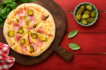 Pizza. Traditional Bacon pizza with ham, mushrooms, pickled cucumber and cheese and cooking ingredients tomatoes basil on wooden table backgrounds. Italian Traditional food. Top view. Mock up.