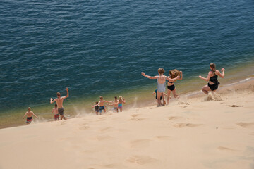 kids running downhill of sand dunes along the lake shore
