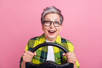 Photo of impressed woman with short hair wear checkered shirt test new vehicle hold steering wheel...