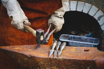 A blacksmith forges iron. Blacksmith's workshop. Blacksmith's anvil and hammer.