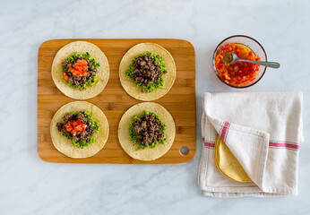 Tortillas on chopping board with salsa
