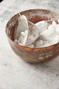 Bowl of lumpy icing sugar with sieve