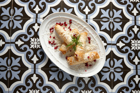 Spring rolls on plate on a tiled floor