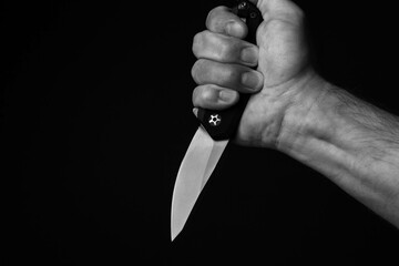 A sharp knife in the man's hand. The use of cold weapons. Knife attack . Armed raid.