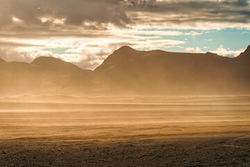 Fototapeta na wymiar Landscape of sandstorm with sunlight blowing on volcanic wilderness in summer