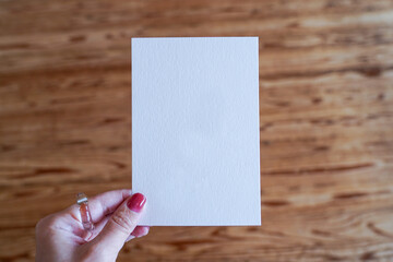 白いポストカードを持つ手