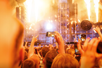 People at concert shooting video or photo using mobile phones