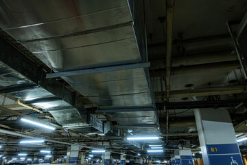 Pipelines in the underground parking of a petroleum and gas refinery run along the ceiling, servicing the industrial complex