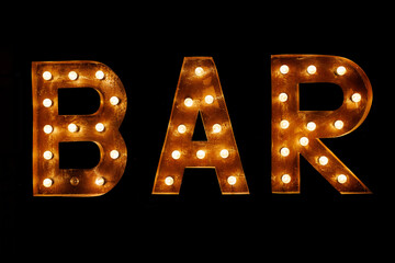 Luminous letters BAR. Volumetric letters from rusty metal with a garland of incandescent lamps.