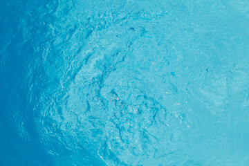 Fototapeta na wymiar Water and air bubbles over blue background,sea wave ,Bokeh light background in the pool,Hotel swimming pool with sunny reflections.
