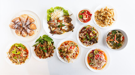 Top view Thai food on the table: Somtum - Spicy Papaya Salad, Grilled pork neck, Larb moo - Spicy...