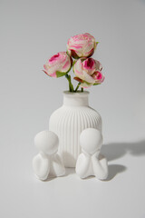 Small white ceramic vase - figurine of human couple. handmade symbolic ceramic figurines on white background