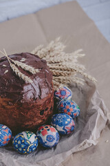 Easter cake, easter eggs and ears of wheat on a gray background