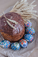 Easter cake, easter eggs and ears of wheat on a gray background