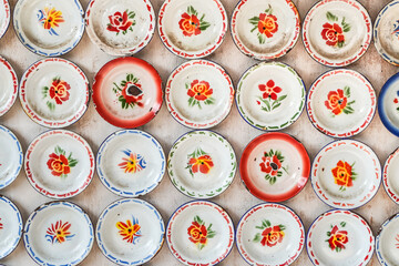 Modern interior design of dining room or workplace with arranged enameled plate. Hanging metal ornament texture on white wall background.