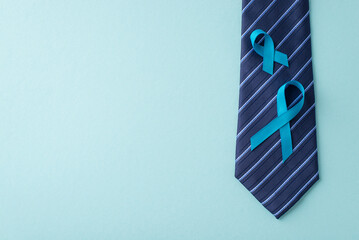 Supporting Men's Well-being. Top view of prostate cancer symbols - blue ribbons on necktie - on a...
