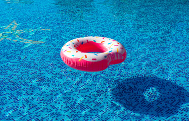 Pink inflatable donut swimming ring in a swimming pool