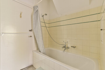 a bathroom with a bathtub, shower curtain and toilet paper on the wall next to the tub is white
