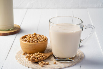 Soy milk in glass and grains soy bean on white table,Alternative milk,healthy concept.