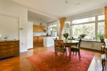 a kitchen and dining area in a house with wood floors, hardwood flooring and an orange rug on the floor