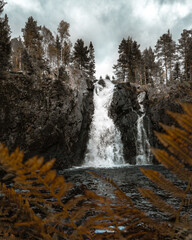 A view of beautiful waterfall with autumn colored leaves on foreground. Hepokongas waterfall in...