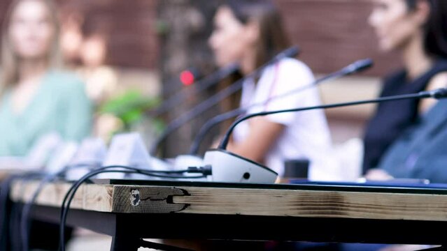 Press conference, public event, round table or political meeting, blurred unrecognizable female speaker