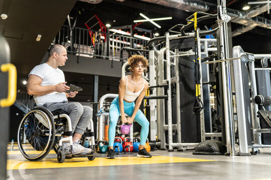 Physically, challenged fitness instructor trains his female client, demonstrating determination and dedication to their fitness journey.