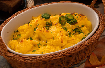 Vegan mashed poatoes as part of a plant-based Thanksgiving table setting, served in vintage ceramic and  wicker woven basket